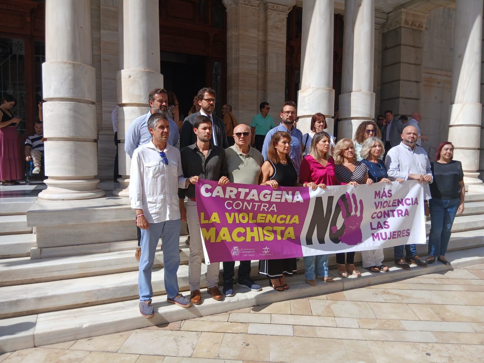 Representantes de varios grupos municipales posan con una pancarta contra la violencia machista en las escaleras del Palacio Consistorial