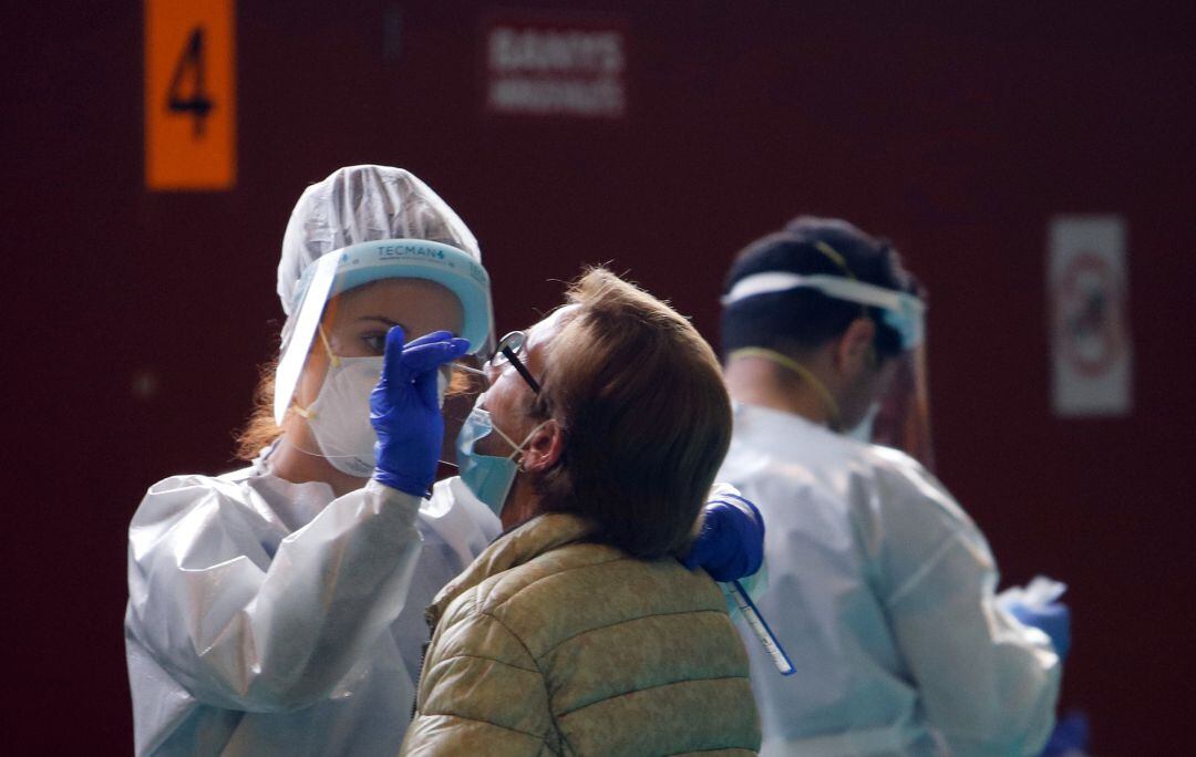 Una profesional sanitaria toma muestras a una mujer