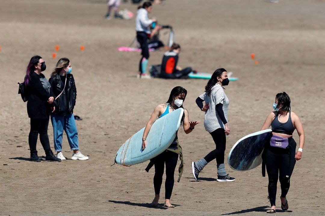 Un grupo de jóvenes disfruta de la playa de la Malvarrosa de València.