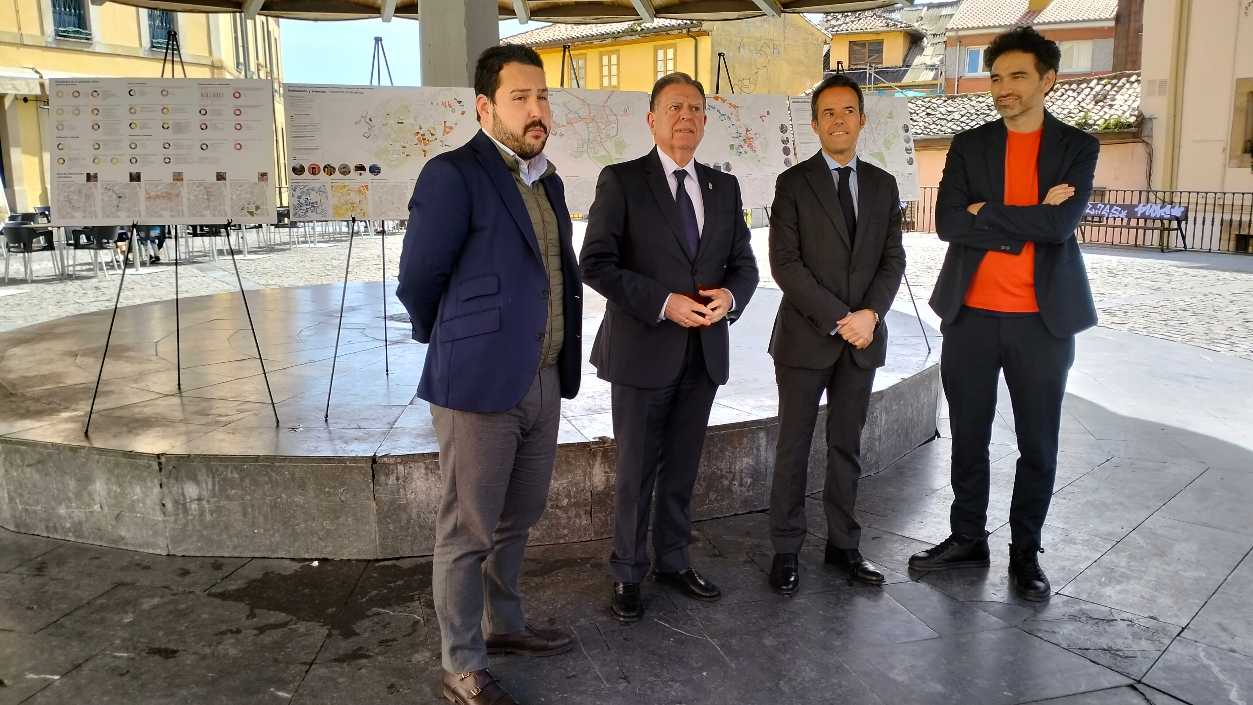 El alcalde, Alfredo Canteli, junto al concejal de Urbanismo, Nacho Cuesta, posan en la Plaza del Paraguas con el arquitecto Juan Tur delante de varios paneles explicativos del plan presentado