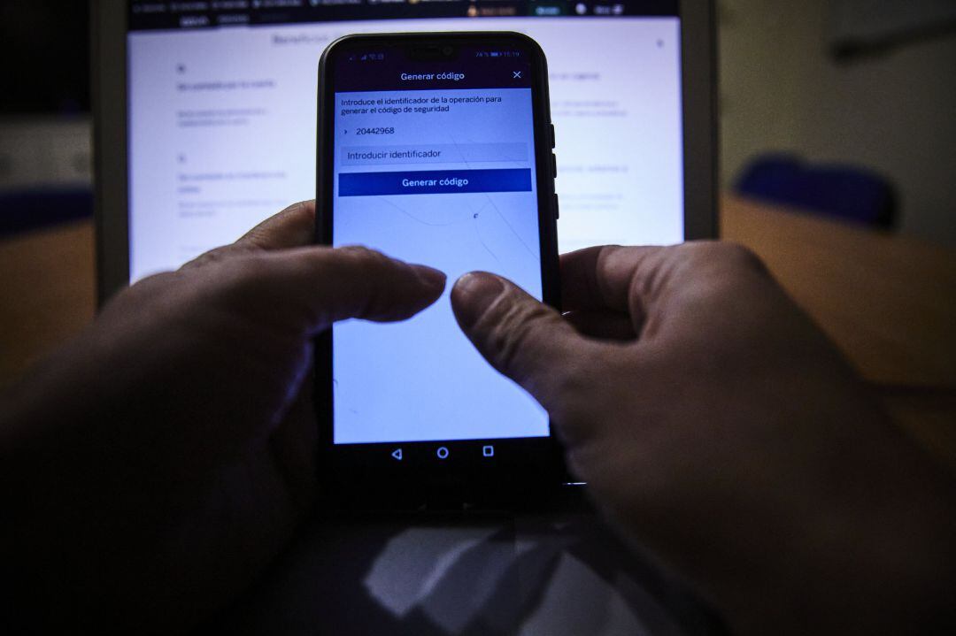 Una persona trabaja con el móvil y el ordenador encendidos, en una imagen de archivo.