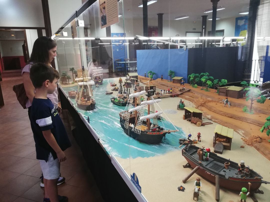 Madre e hijo junto a una de las cinco maquetas que componen la exposición