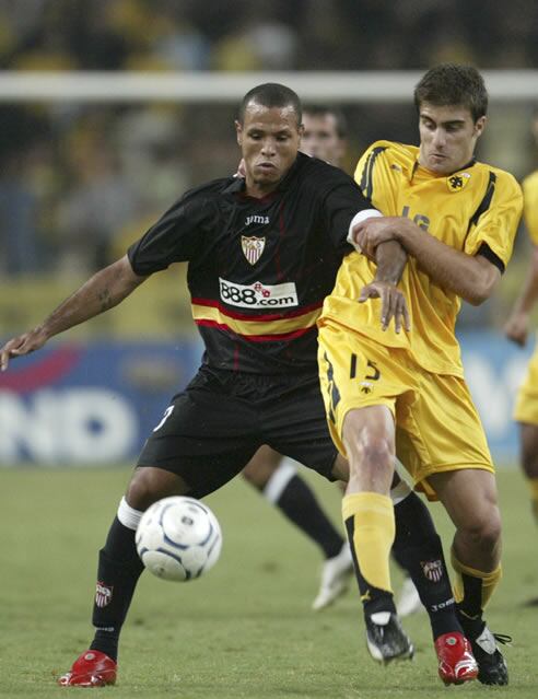 El jugador del AEK Papastathopoulos, lucha por el balón con el sevillista Fabiano