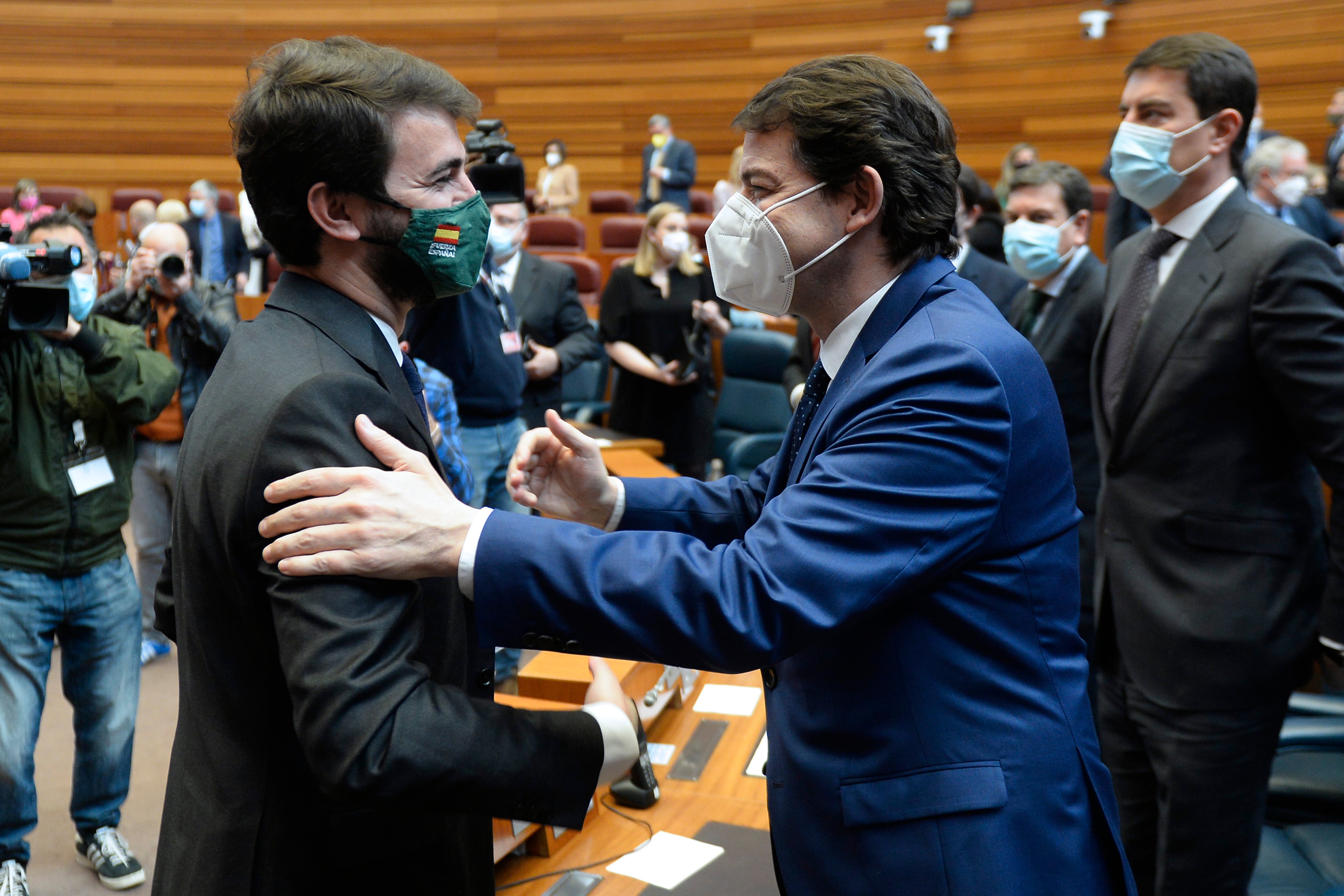 El presidente en funciones de la Junta de Castilla y León, Alfonso Fernández Mañueco (d), saluda al candidato de Vox a la presidencia , Juan García-Gallardo (i), tras el pleno de constitución del parlamento regional.