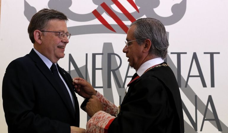 El president de la Generalitat, Ximo Puig, recibe de manos del presidente del Consell Jurídic Consultiu, Vicente Garrido, la insignia de la institución, en el vigésimo aniversario de la misma.