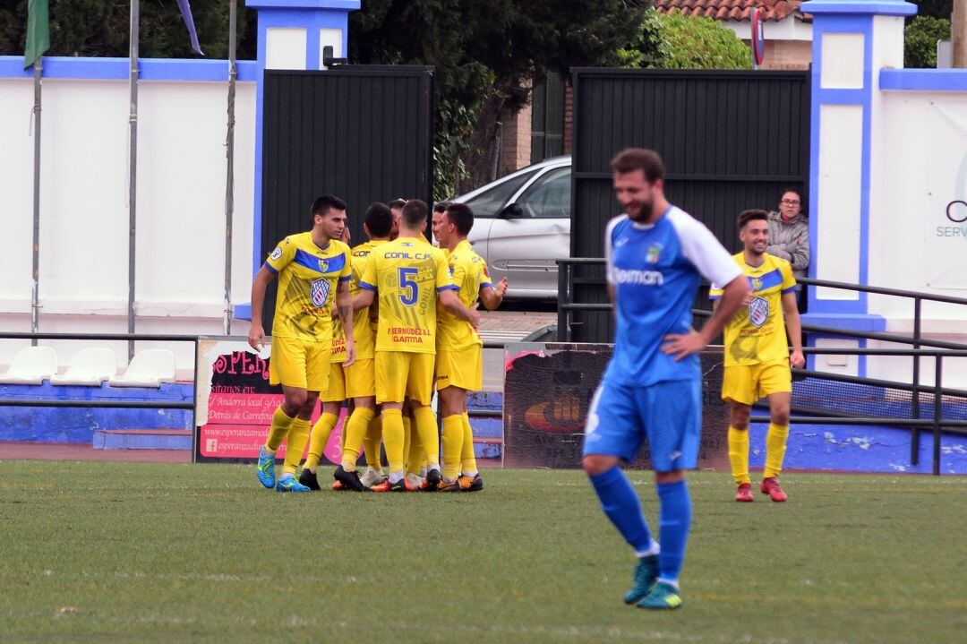 Jugadores del Conil celebrando uno de los goles ante la desolación de un futbolista del Guada