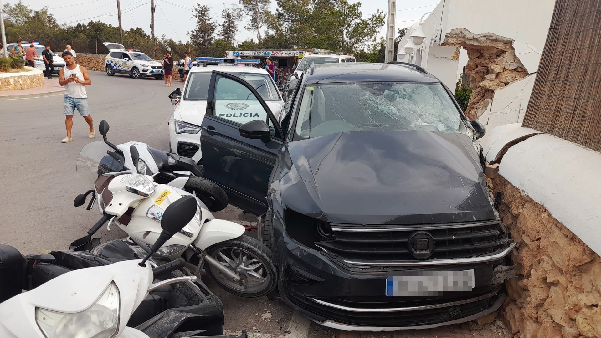 El vehículo tras estrellarse contra una vivienda y destrozar varias motocicletas