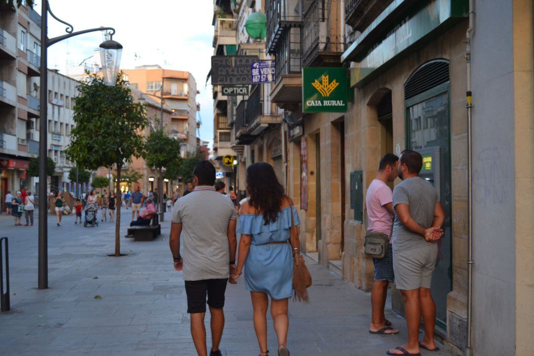 Personas sacando dinero de un cajero a las puertas de una entidad bancaria