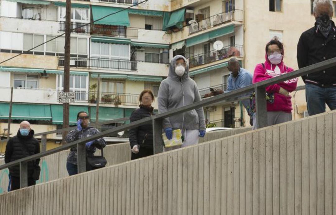 Personas haciendo cola para acceder a un comercio en pleno confinamiento