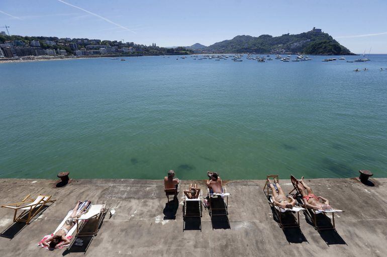 Varias personas toman el sol en el Real Club Náutico de San Sebastián