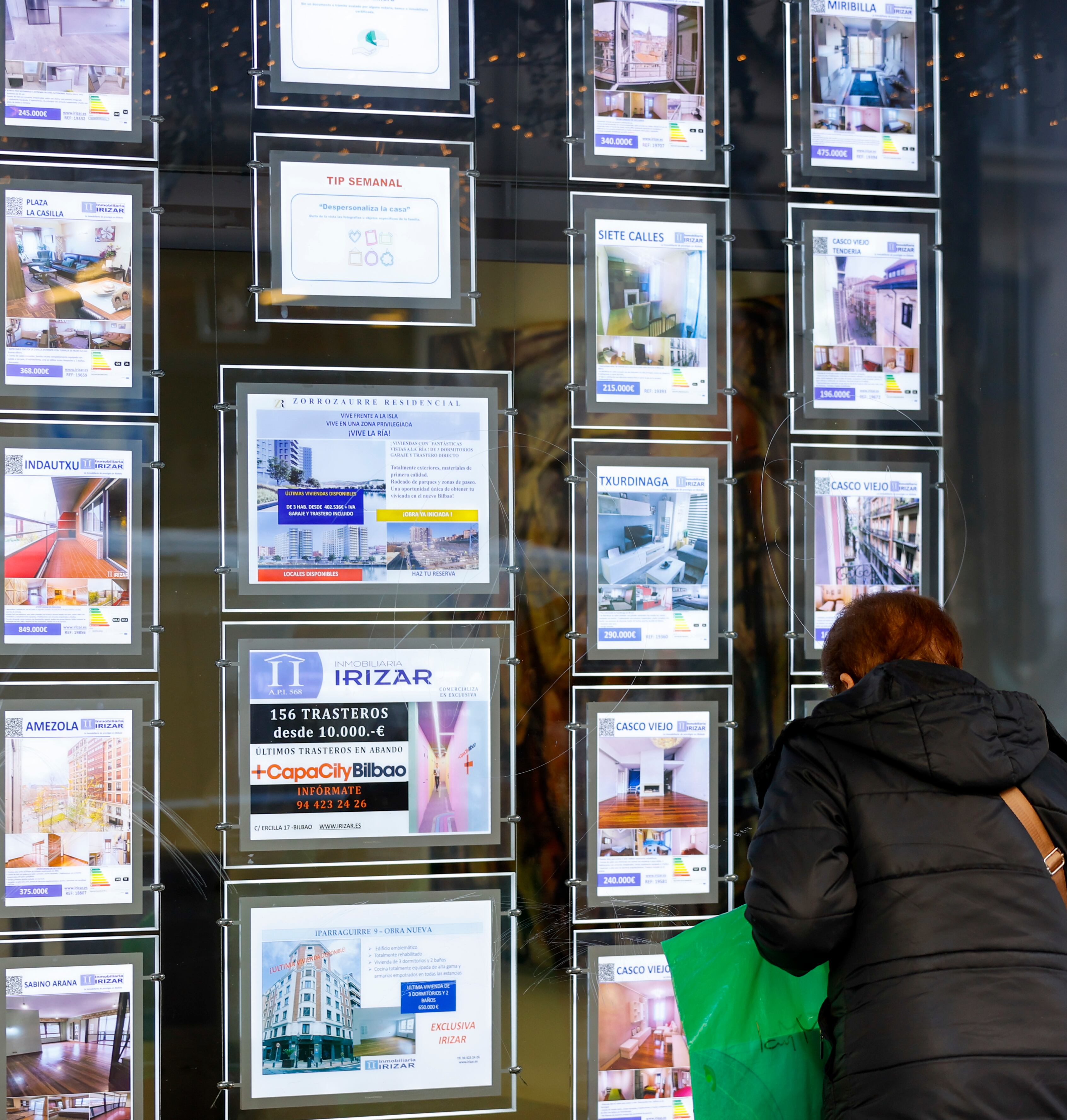 Una mujer observa en una inmobiliaria la oferta de viviendas.