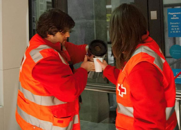 Voluntaris de la Creu Roja reparteixen cafè i roba d&#039;abric als indigents