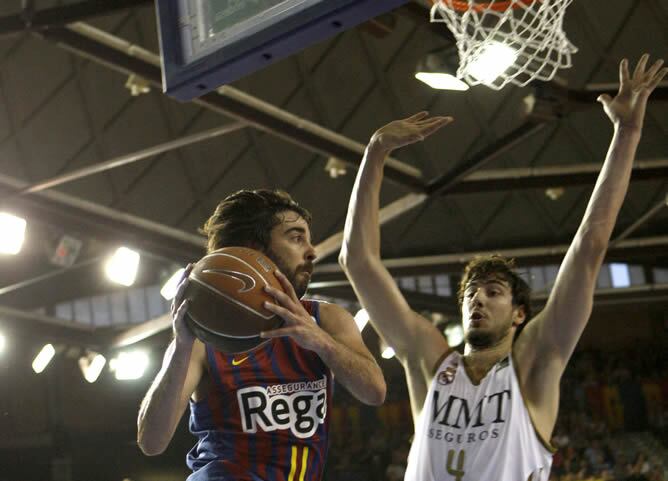 El jugador del Barça Regal, el escolta Juan Carlos Navarro (i) salta con la pelota ante la resistencia del pívot croata Ante Tomic (d), del Real Madrid durante el primer partido del &quot;play-off&quot; final de la liga ACB