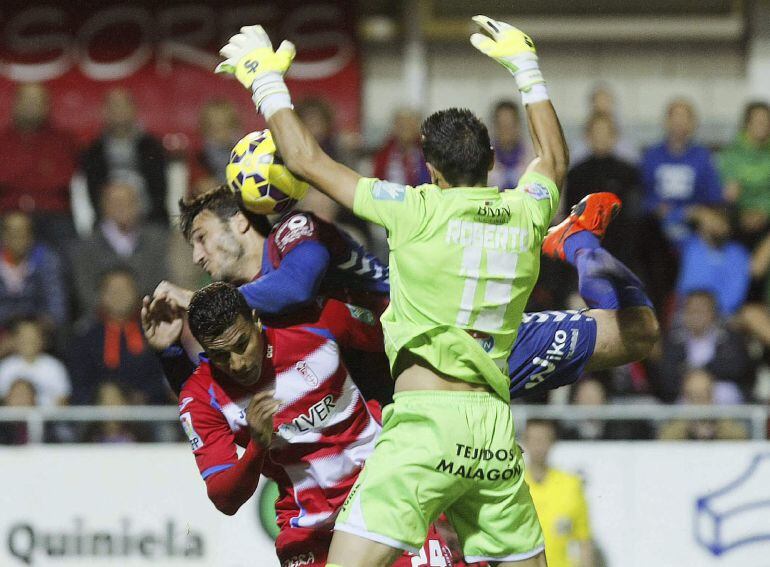 El delantero italiano del Eibar Piovaccari disputa un balón con Roberto y Jeison Murillo, del Granada.