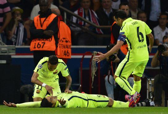 Barcelona&#039;s Uruguayan forward Luis Suarez (down) celebrates with Barcelona&#039;s Brazilian forward Neymar da Silva Santos Junior (L) and Barcelona&#039;s midfielder Xavi Hernandez after scoring during the UEFA Champions league quarter-final first leg football match PSG vs FC Barcelona at the Parc des Princes stadium in Paris on April 15, 2015. AFP PHOTO / FRANCK FIFE