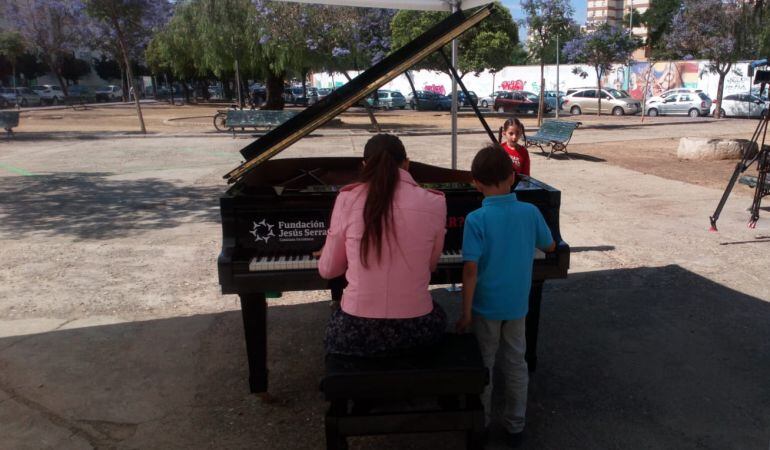 La profesora saray Jiménez toca el piano junto a Jaime, uno de su alumnos