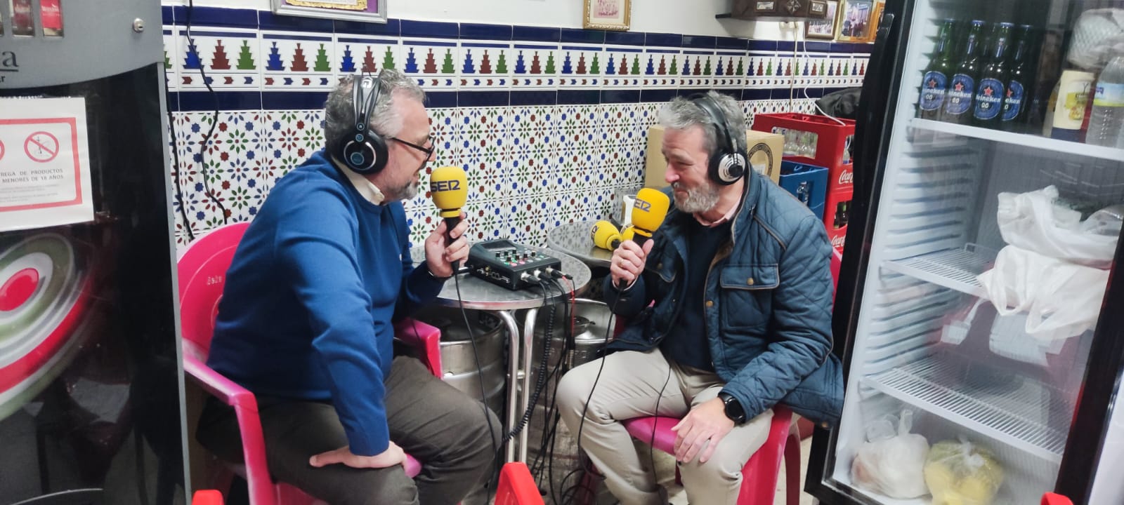 Manolo Bustillo, hermano mayor electo de Pino Montano (a la derecha), atiende a Paco García durante la emisión del programa Cruz de Guía del pasado 8 de diciembre