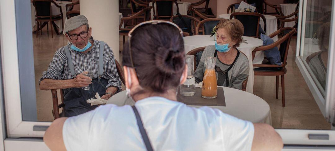 Una mujer conversa con sus padres en una residencia