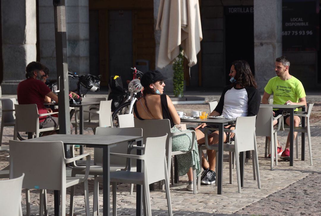 Varias personas disfrutan de la terraza de un bar abierto en la fase 1  