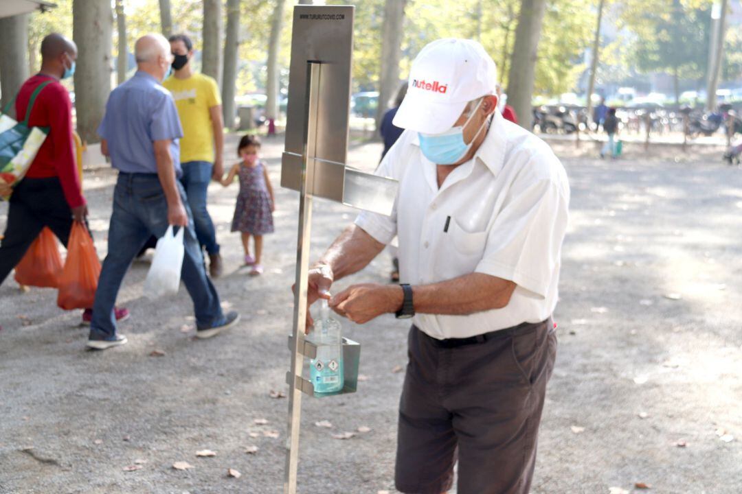Un home posant-se gel hidroalcohòlic a l'entrada del mercat de la Devesa