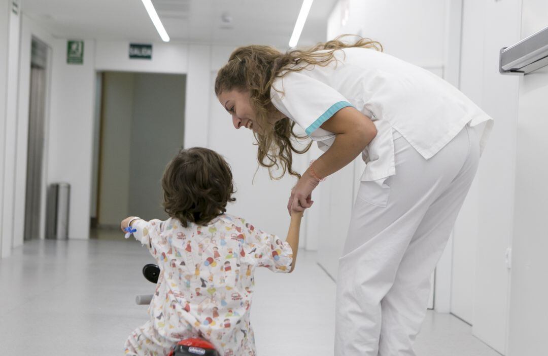 Niño hospitalizado con minimoto y enfermera de Quirónsalud