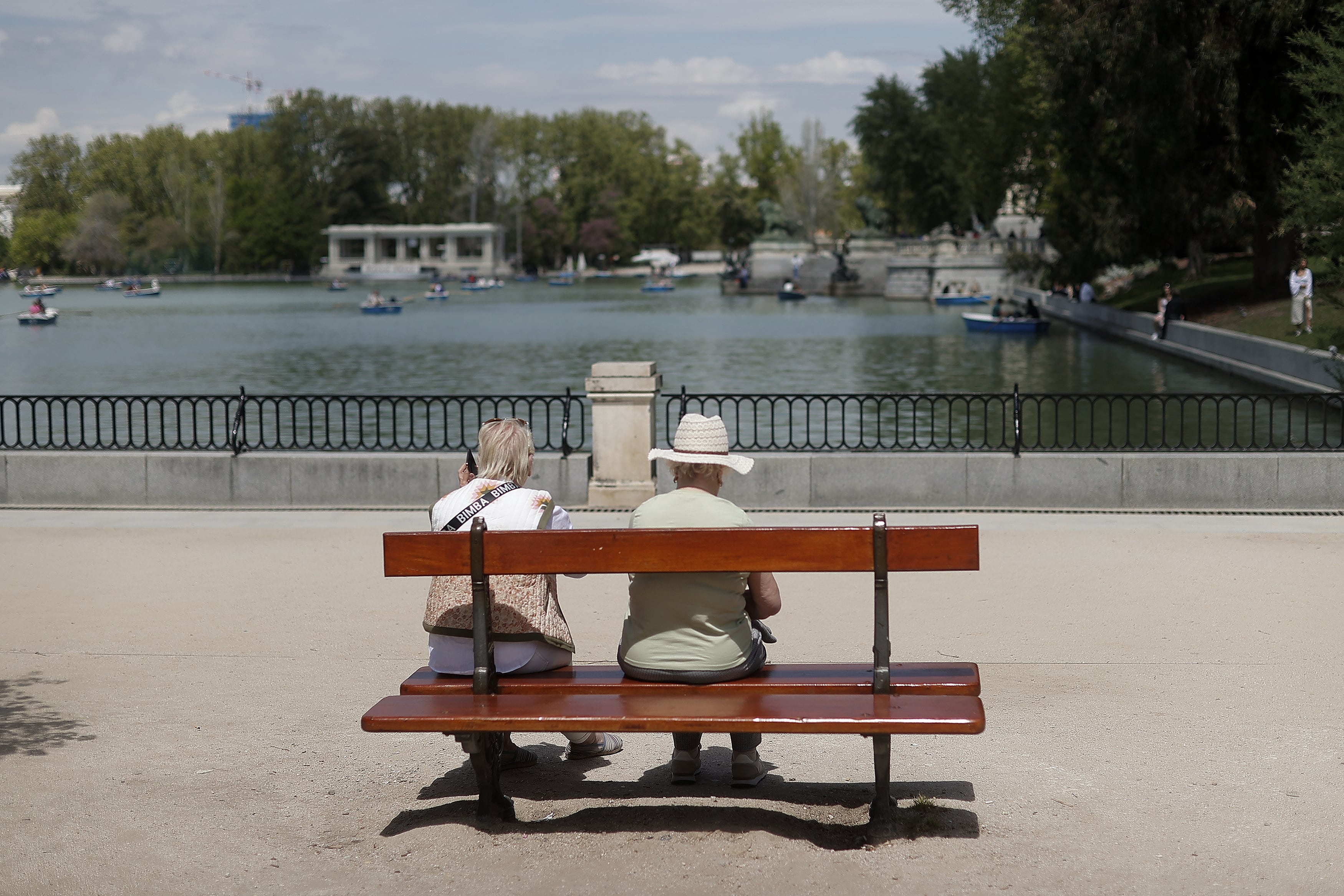 Dos ancianas descansan en un banco de El Retiro.