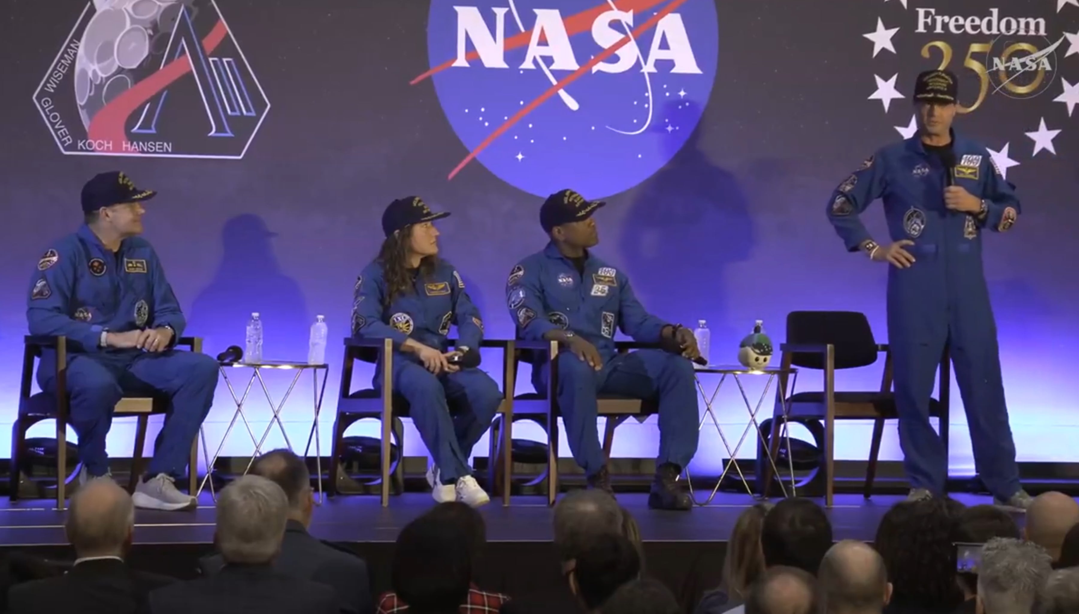 Captura de pantalla de una transmisión de la NASA de los integrantes de la misión Artemis II, los astronautas de la NASA, el piloto Victor Glover (i), la especialista de misión Christina Koch (2-i), el astronauta de la Agencia Espacial Canadiense (CSA), el especialista de misión Jeremy Hansen (2-d) y el comandante Reid Wiseman (d), hablando durante un evento este sábado.