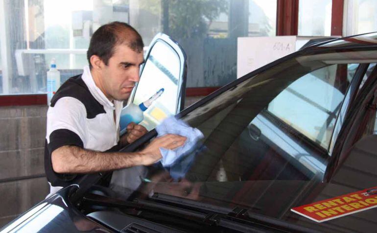 Un operari d'un túnel de rentat de cotxes.