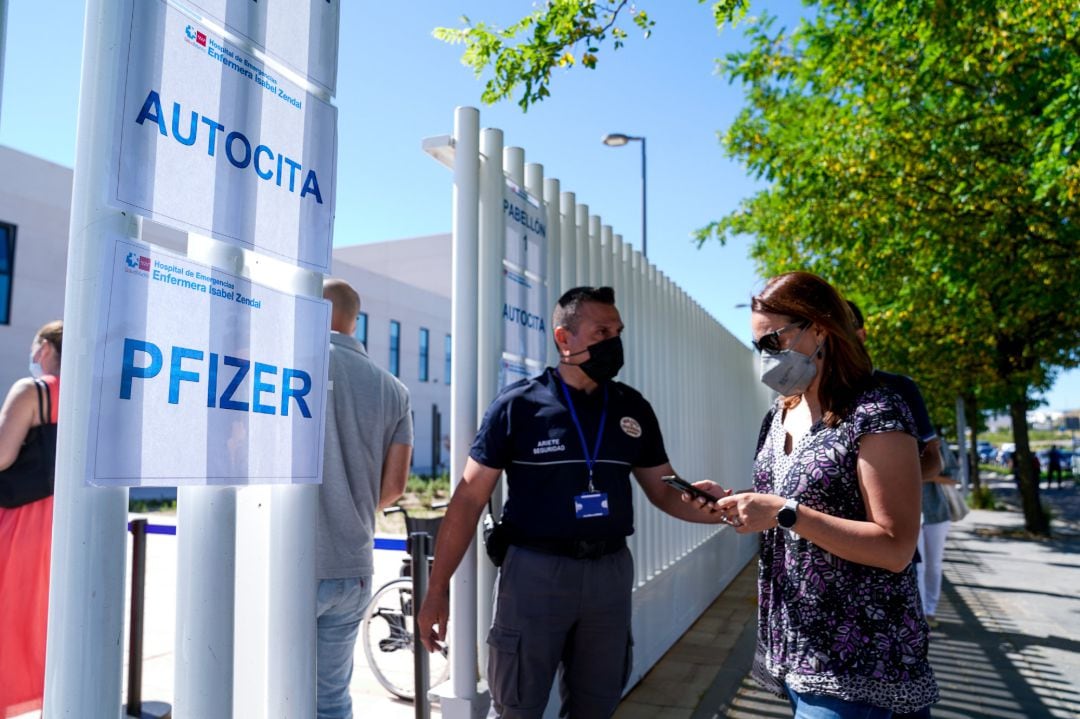 Un policía controla la entrada de varias personas a las afueras del Hospital público de emergencias Enfermera Isabel Zendal,