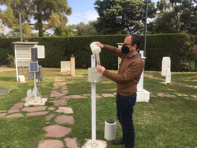 José Ángel Núnez junto a un Pluviómetro que mide la cantidad de agua que cae por m2