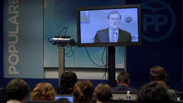 Los periodistas siguen a través de un monitor la intervención de Mariano Rajoy.