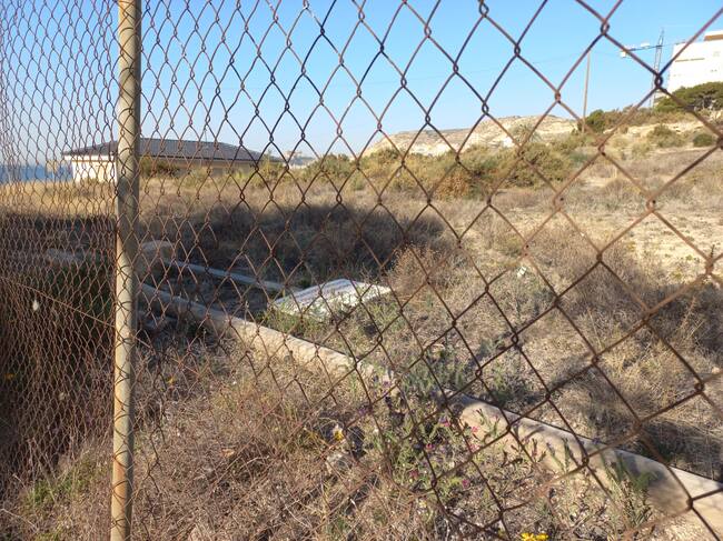 Cartel caído en el solar de la Almadraba vallado por ser un yacimiento arqueológico