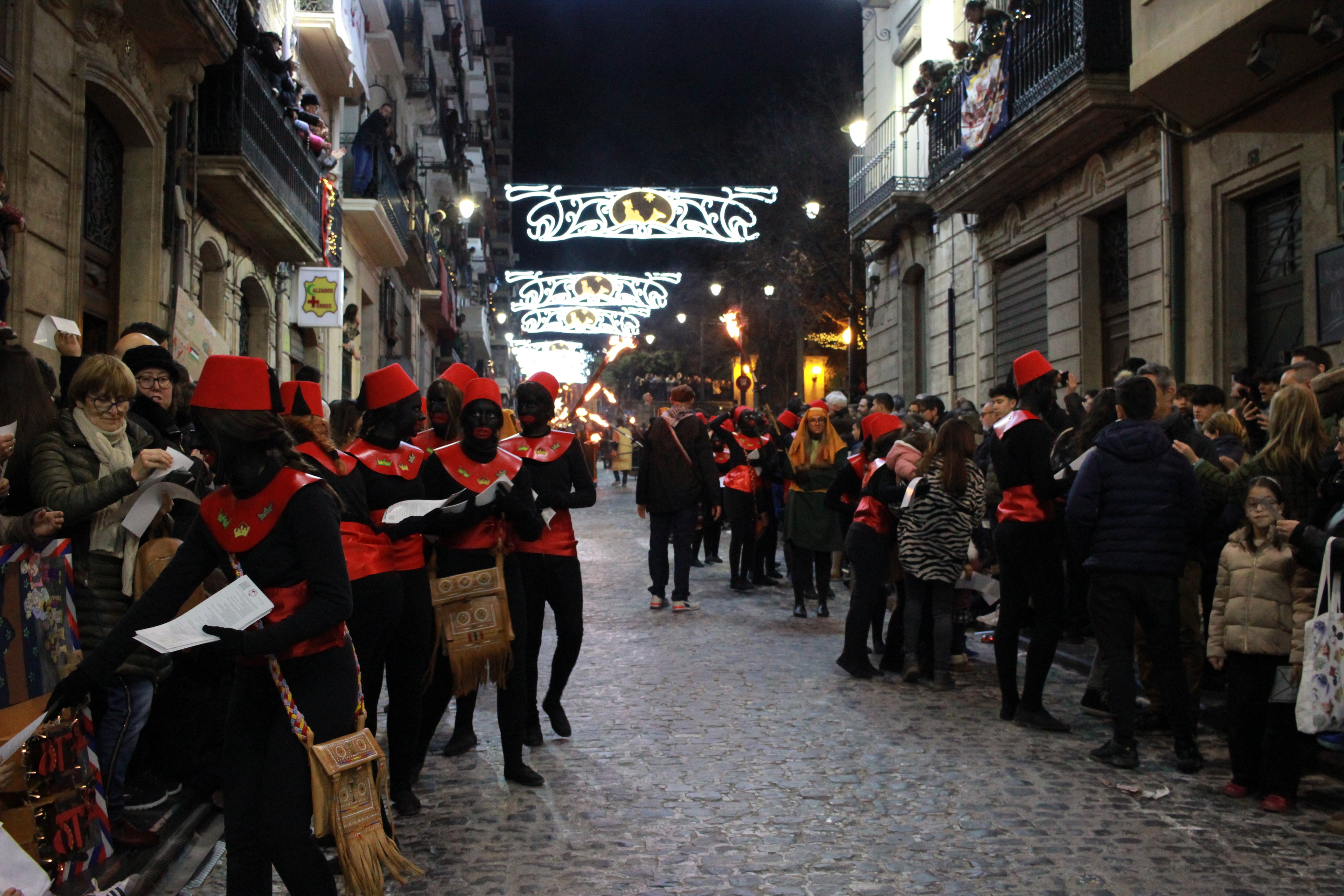 Los pajes repartiendo copias del Bando Real de 2025 por las calle San Nicolás.