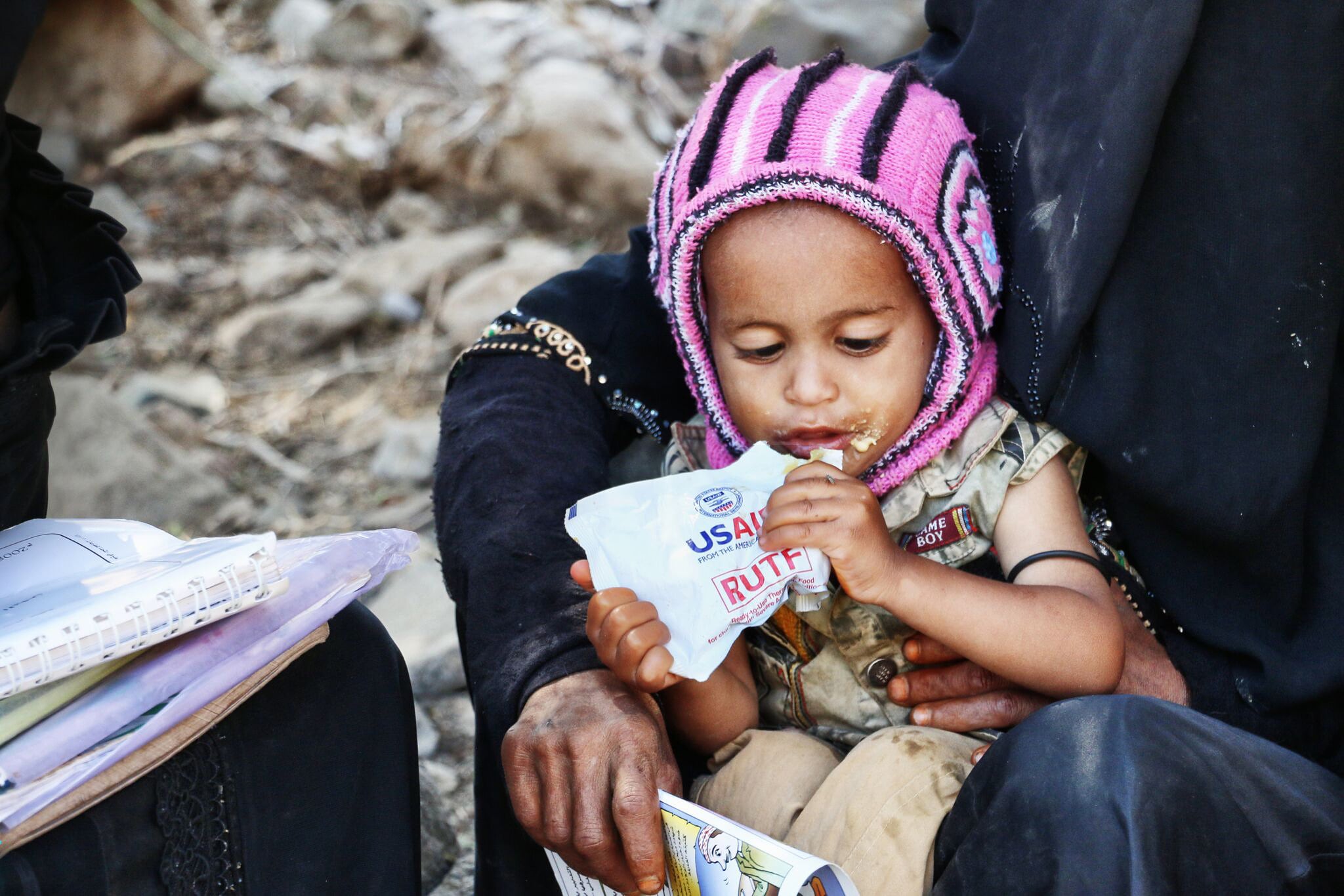 Una niña con una bolsa de comida enviada por USAID a Yemen