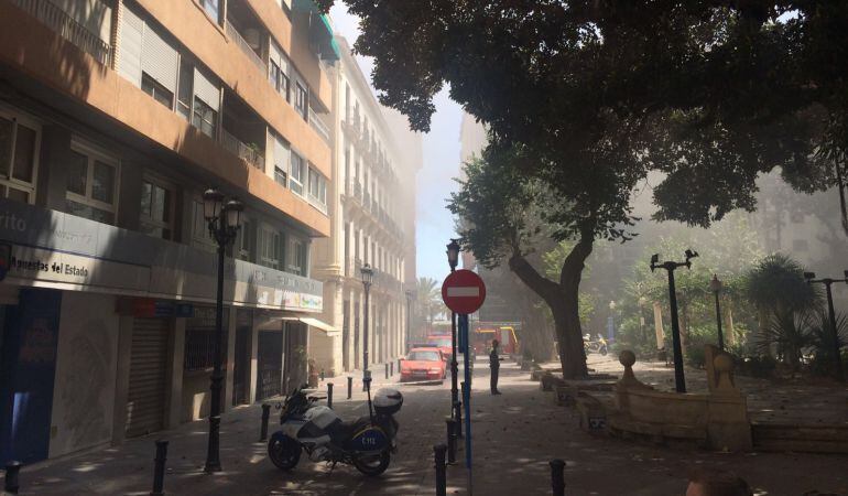 Plaza de Gabriel Miró cubierta por el humo del incendio. Efectivos de bomberos al fondo, a la altura del Colegio de Arquitectos