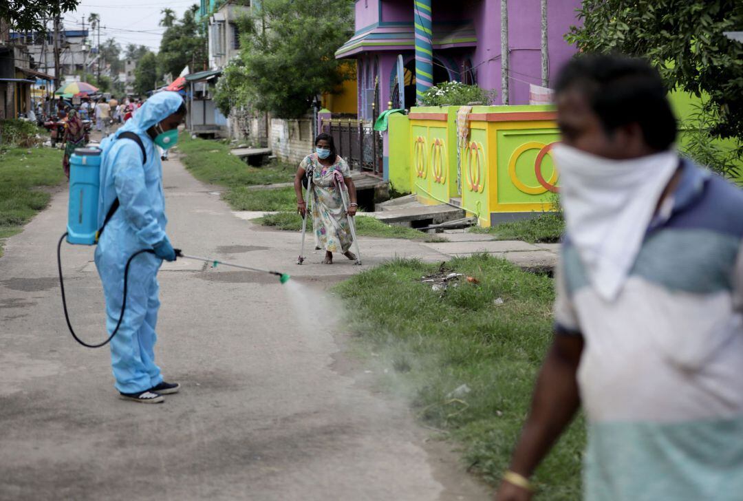 Un trabajador de la India desinfecta la calle en Kolkata