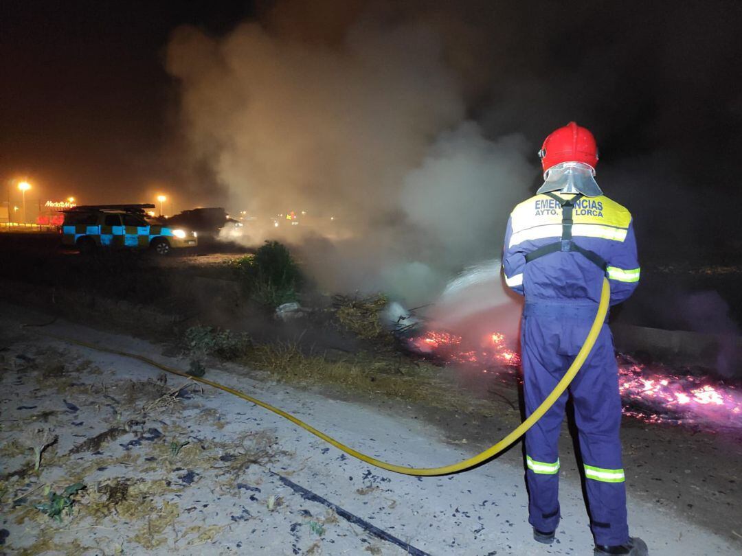 Un efectivo del Servicio de Urgencias interviene para apagar una hoguera.