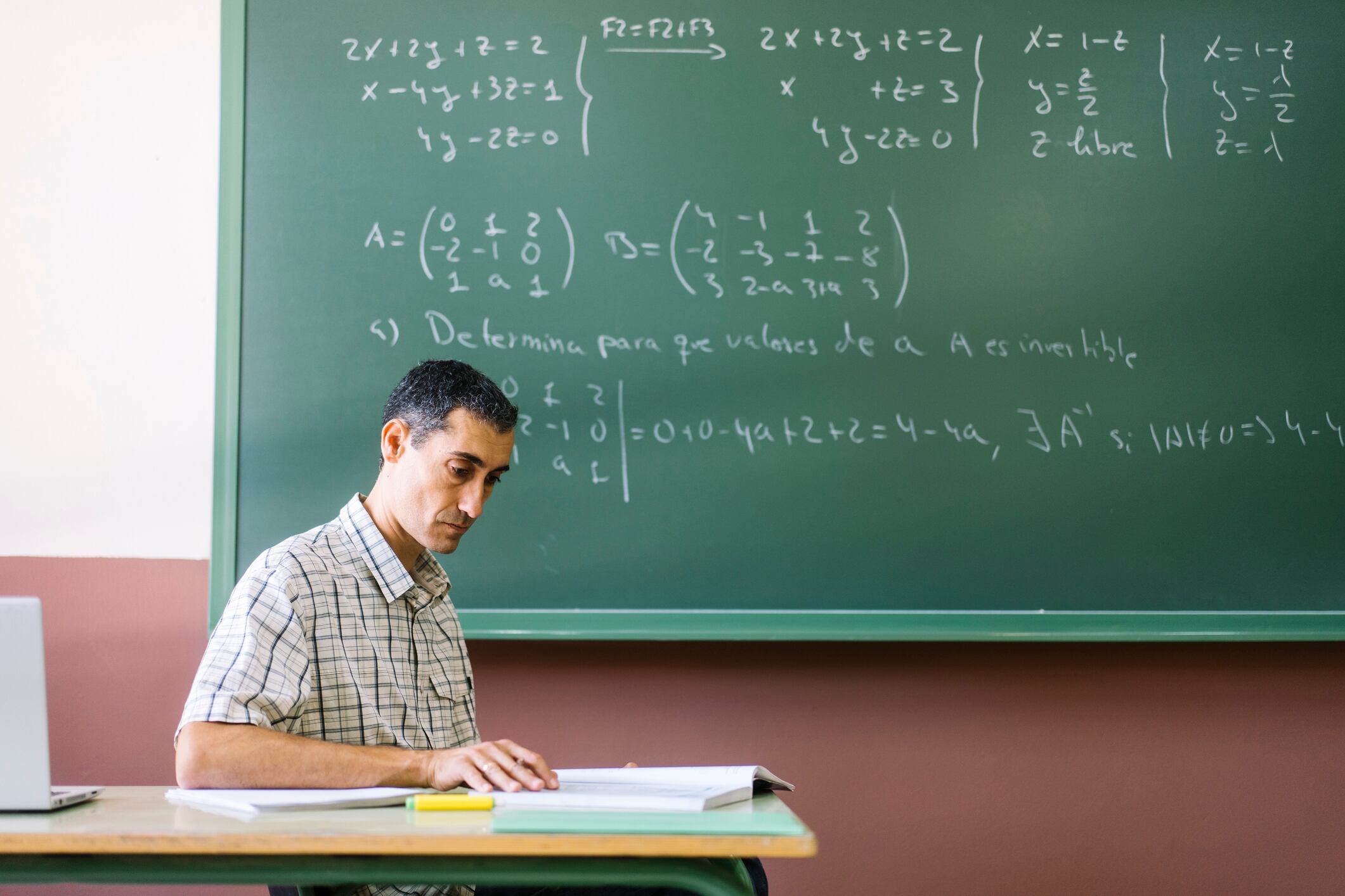 Math teacher reading book in classroom