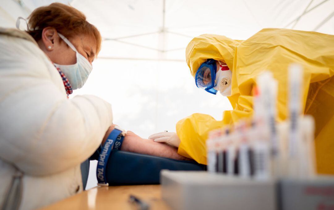 Una estudiante de medicina extrae una muestra de sangre a una mujer con coronavirus en Berlín.