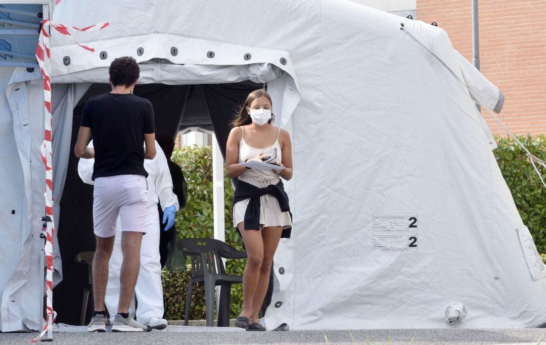 Una chica sale de área portatil ubicada frante a un hospital tras realizarle el personal sanitario una PCR.