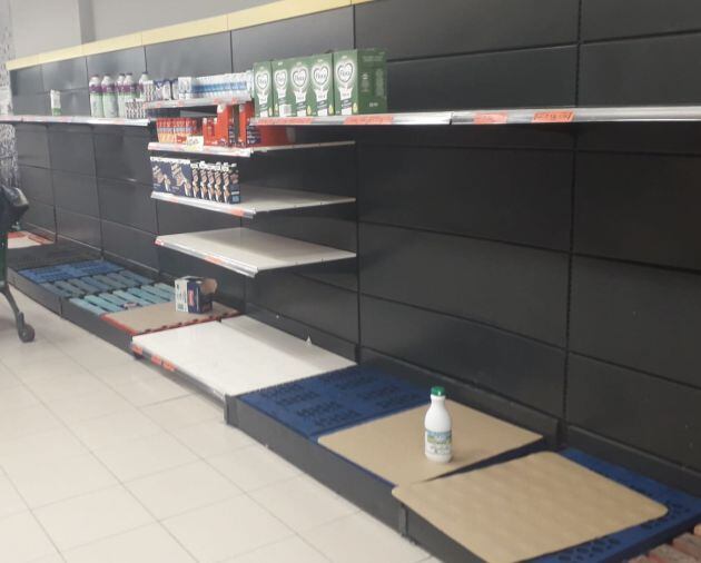 Estado de una de las estanterías destinada al agua y la leche en un supermercado segoviano