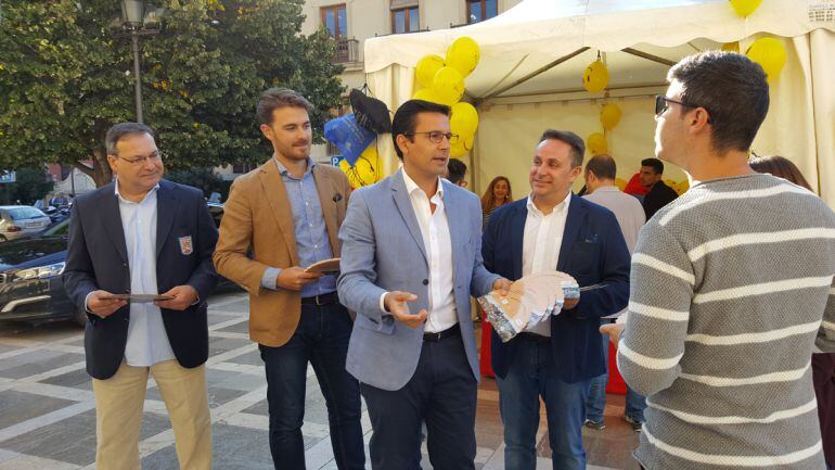 El presidente de la patronal hostelera de Granada, el delegado de Turismo de la Junta, el alcalde de Granada y el diputado de Turismo de la Diputación entregan propaganda a dos visitantes en el Día Mundial del Turismo