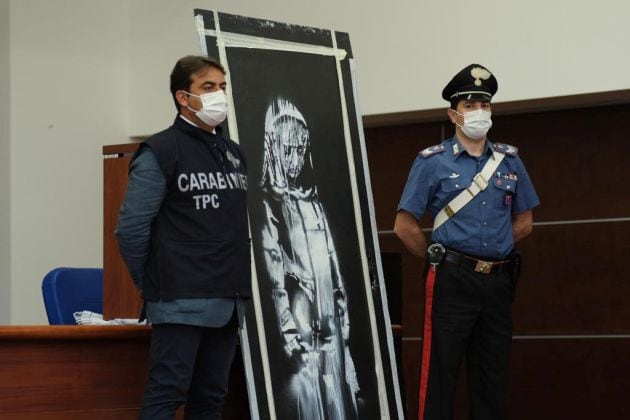 Carabinieri junto al mural de Banksy recuperado