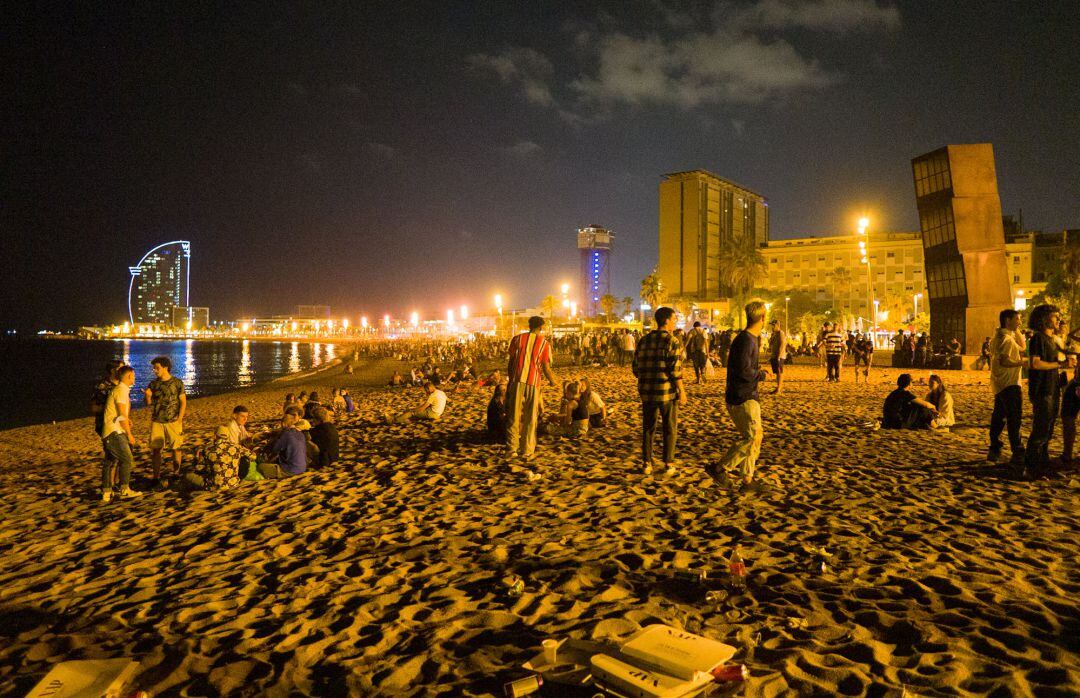 Jóvenes se reúnen en la playa de la Barceloneta horas antes de que entre en vigor el toque de queda en Cataluña.