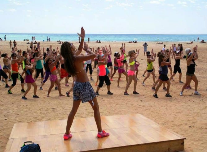 Grupo de personas hacen ejercicio en la playa