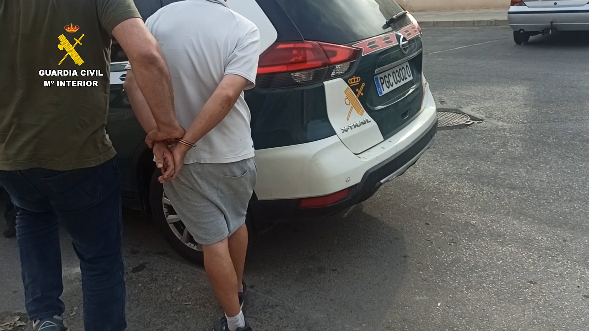 Los agentes escoltan a un detenido al vehículo policial