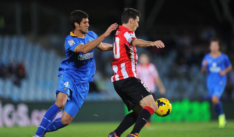 El entonces azulón Lisandro Lopez (i) pugna con el rojiblanco Aritz Aduriz por un balón durante el partido entre Getafe C.F. y Athletic Club disputado en el Coliseum Alfonso Perez durante la temporada 2013-2014.