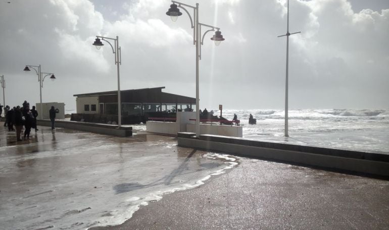 El chiringuito El Potito, al fondo, durante el temporal del 1 de marzo en Cádiz