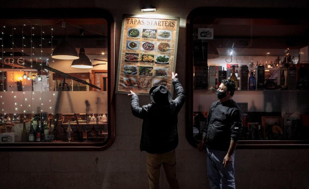 Unos trabajadores de un restaurante del centro de València recogen la terraza el día que se aplica en la Comunitat Valenciana las nuevas medidas contra la pandemia de coronavirus