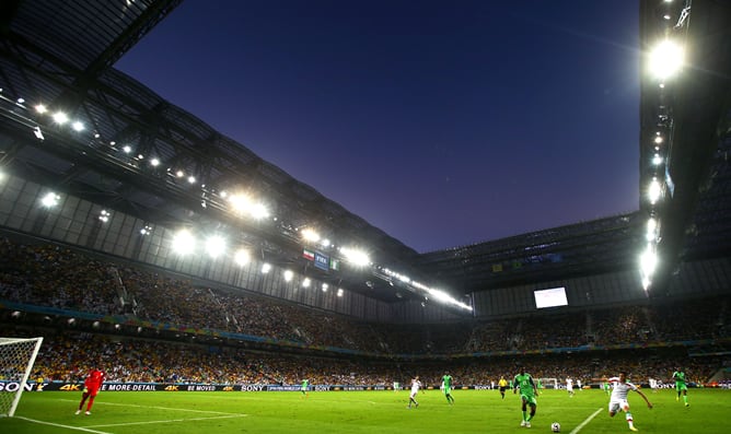 Un jugador iraní y otro nigeriano pugnan la pelota en el Arena da Baixada.